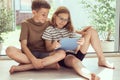 Teenage siblings children playing using tablet outdoor at home in summer sunny day