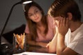 Teenage Sister Helping Stressed Younger Brother With Studies At Desk In Bedroom In Evening Royalty Free Stock Photo