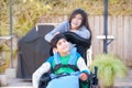 Teenage sister taking care of disabled brother in wheelchair out