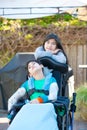 Teenage sister taking care of disabled brother in wheelchair out
