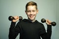 Teenage sport boy with dumbbells and stylish haircut, studio shot Royalty Free Stock Photo