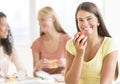 Teenage Student Eating Apple In University Canteen