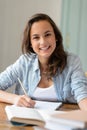 Teenage student girl studying at home smiling Royalty Free Stock Photo