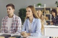 Teenage student sitting at desk in classroom looking and listening attentively