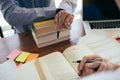 Teenage student works on homework in his room and writing in notebook