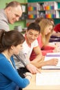 Teenage Students Studying In Classroom With Tutor