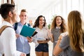 Teenage students walking in high school hall, talking.