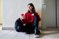 Teenage trendy male with smartphone backpack sitting on the floor Royalty Free Stock Photo