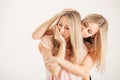 Twins sisters comforting tearful friend on white