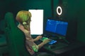 Teenage white girl wearing cute ponytails sitting in gaming chair using professional computer with ring light. Dark