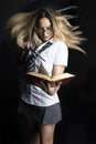 Teenage witch casting a spell over a magical book - digital composite with effects included