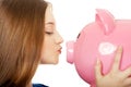 Teenage woman kissing piggybank. Royalty Free Stock Photo