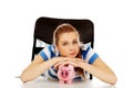Teenage woman with piggybank on the table Royalty Free Stock Photo