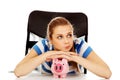 Teenage woman with piggybank on the table Royalty Free Stock Photo