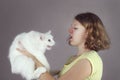 A teenaged allergic girl holds a angora cat Royalty Free Stock Photo