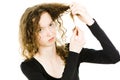 Teenaged blond girl with curly hair having tangled hair ends problem Royalty Free Stock Photo