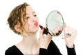 Teenaged girl in black dress making make up in round mirror - lipstick