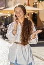 Happy child girl having remote conversation talking on smartphone, good news gossip in city street Royalty Free Stock Photo