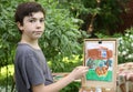 Teenager artist boy in garden painting picture of jasmin flowers and cottage house Royalty Free Stock Photo