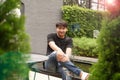 Teenager Asian model with smiling face and happiness sitting on bench outdoor in nature park. Portrait person in summer, sunny day Royalty Free Stock Photo