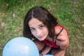 Teenager with balloons and a red beast on the grass