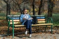 A teenager on a bench is doing homework on a sunny autumn day. Royalty Free Stock Photo