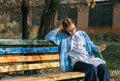 A teenager on a bench is doing homework on a sunny autumn day. Royalty Free Stock Photo