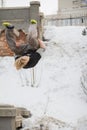 Teenager blonde hair guy training parkour jump flip in the snow covered park