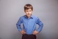 Teenager boy angry hands on hips gray background