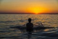 Teenager boy bathing in the sea at sunset in Sicily Royalty Free Stock Photo