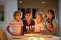 Teenager boy birthday. Siblings blow cake candles Royalty Free Stock Photo