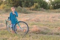 Teenager boy with blue bike in farm field Royalty Free Stock Photo