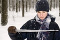 Teenager boy in a blue jacket, in a checkered scarf and in a dark blue hat with a icicle in his hands Royalty Free Stock Photo