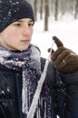 Teenager boy in a blue jacket, in a checkered scarf and in a dark blue hat with a icicle in his hands Royalty Free Stock Photo