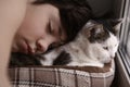 Teenager boy and cat in cozy cat bed nest sleeping on the weekend morning Royalty Free Stock Photo