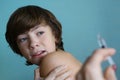Teenager boy in doctors cabinet undergo vaccination afraid
