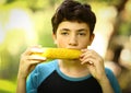 Teenager boy eating boiled corn cob close up photo Royalty Free Stock Photo