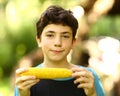 Teenager boy eating boiled corn cob close up photo Royalty Free Stock Photo