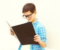 Teenager boy in eyeglasses is looking or reading book on white Royalty Free Stock Photo