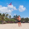Teenager boy flying a kite on tropical beach Royalty Free Stock Photo