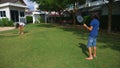 A teenager boy and girl play badminton on a green lawn in the backyard of their home Royalty Free Stock Photo