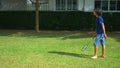 A teenager boy and girl play badminton on a green lawn in the backyard of their home Royalty Free Stock Photo