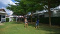 A teenager boy and girl play badminton on a green lawn in the backyard of their home Royalty Free Stock Photo