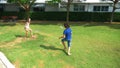 A teenager boy and girl play badminton on a green lawn in the backyard of their home Royalty Free Stock Photo