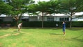 A teenager boy and girl play badminton on a green lawn in the backyard of their home Royalty Free Stock Photo