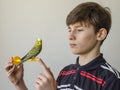 Teenager boy with a green budgerigar