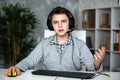 A teenager boy in headphones playing computer games at pc at home in the interior in front of a computer monitor Royalty Free Stock Photo