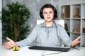 A teenager boy in headphones playing computer games at pc at home in the interior in front of a computer monitor Royalty Free Stock Photo