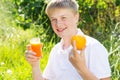 Teenager boy is holding glass with carrot juice Royalty Free Stock Photo