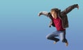 Teenager boy jumping dance movement on a colored blue background